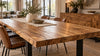 Solid mango wood dining table with a warm honey finish, natural wood grain and subtle dark spalting, featuring black steel legs in a Scandinavian-industrial Dutch dining room